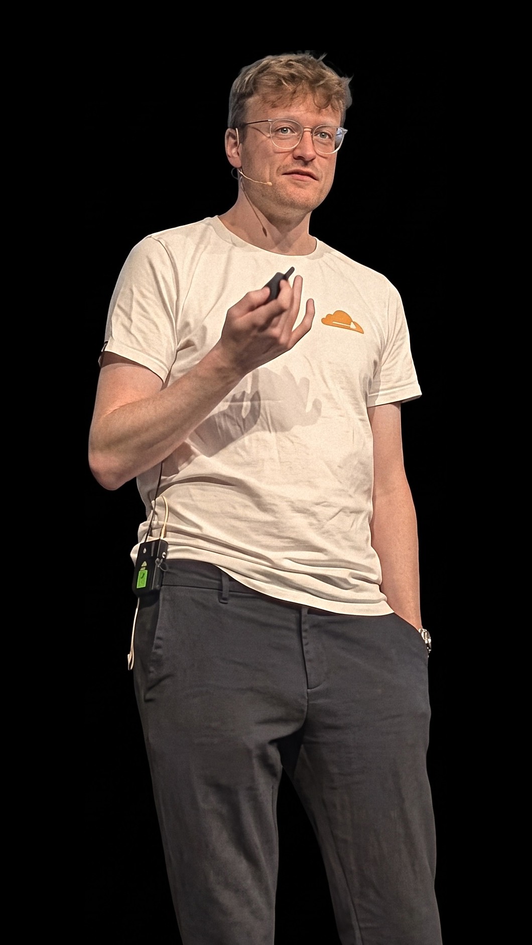 Kai Bitterschulte bei einem Vortrag auf einer Bühne, mit einem Präsentations-Clicker in der Hand